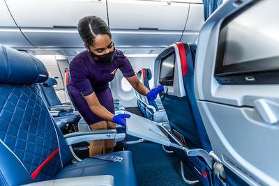 Boeing 757-200 | Delta airlines flight attendant adjusting the seats