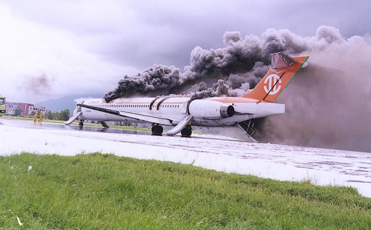 McDonnell Douglas MD-90-30 | Uni Air |  B-17912 | Flight 873 | black clouds pouring out a burning MD-90-30 on the runway covered with foam at Hualien airport 24 August 1999
