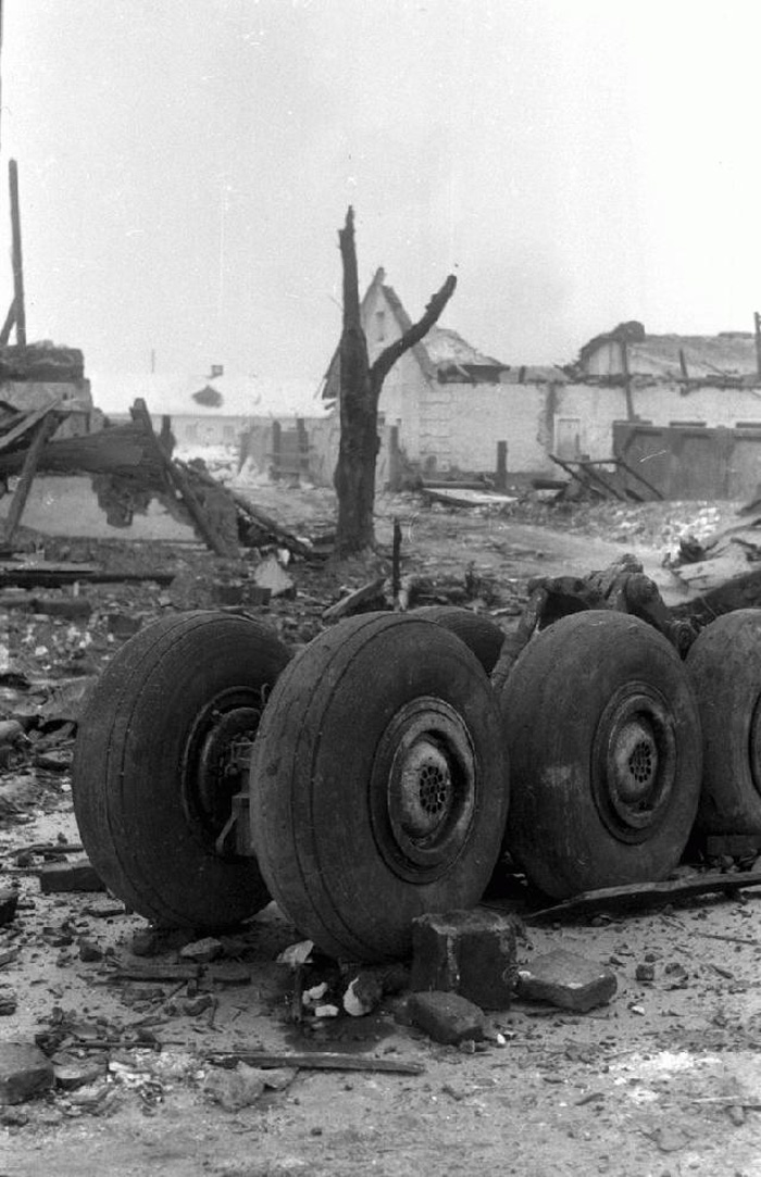 Tupolew Tu-154M RA-85656 bogie landing gear on the crash site with destroyed houses in the back ground