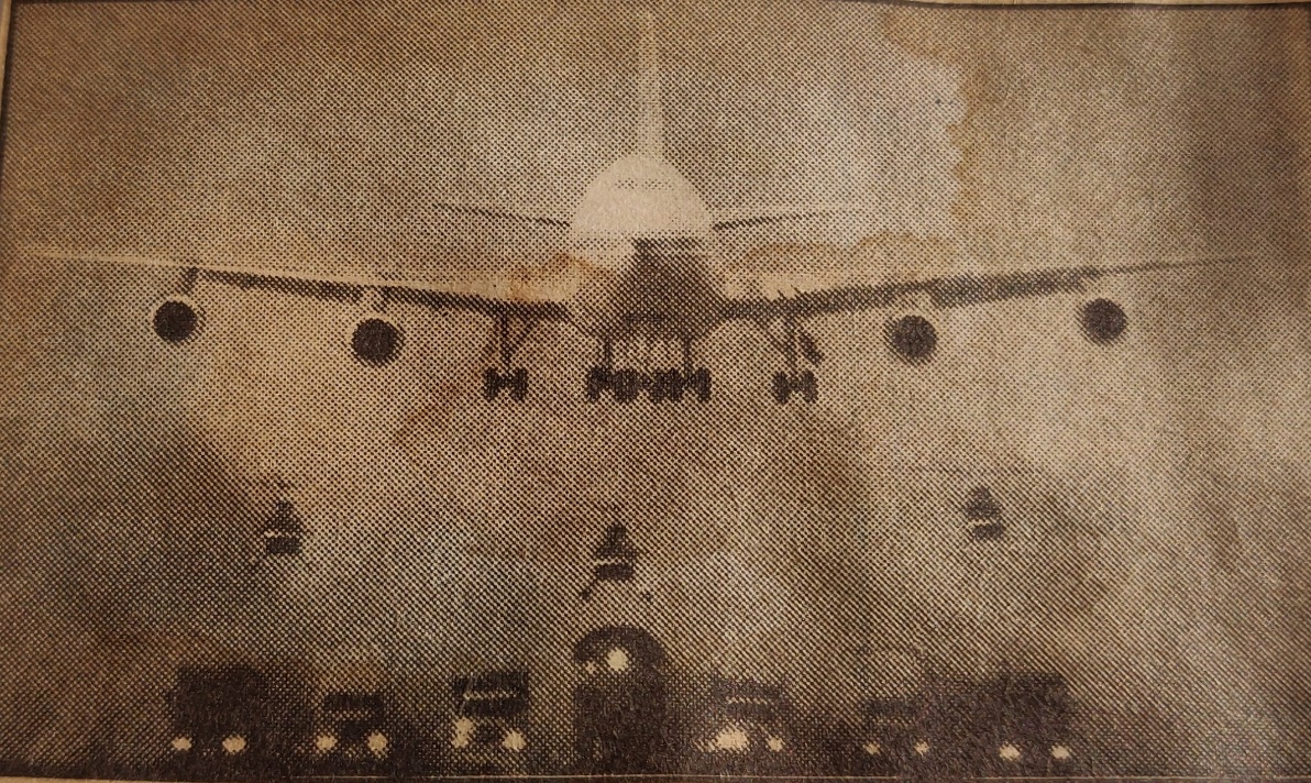 Boeing 747-100 approaching with helicopters and vehicles below | film set