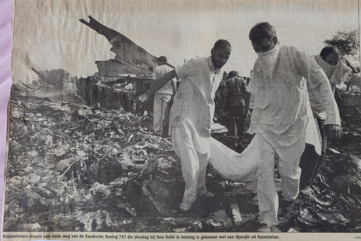 Boeing 747-100 | Saudi Arabian Airlines | HZ-AIH | newspaper picture a human body is carried away from the crash site