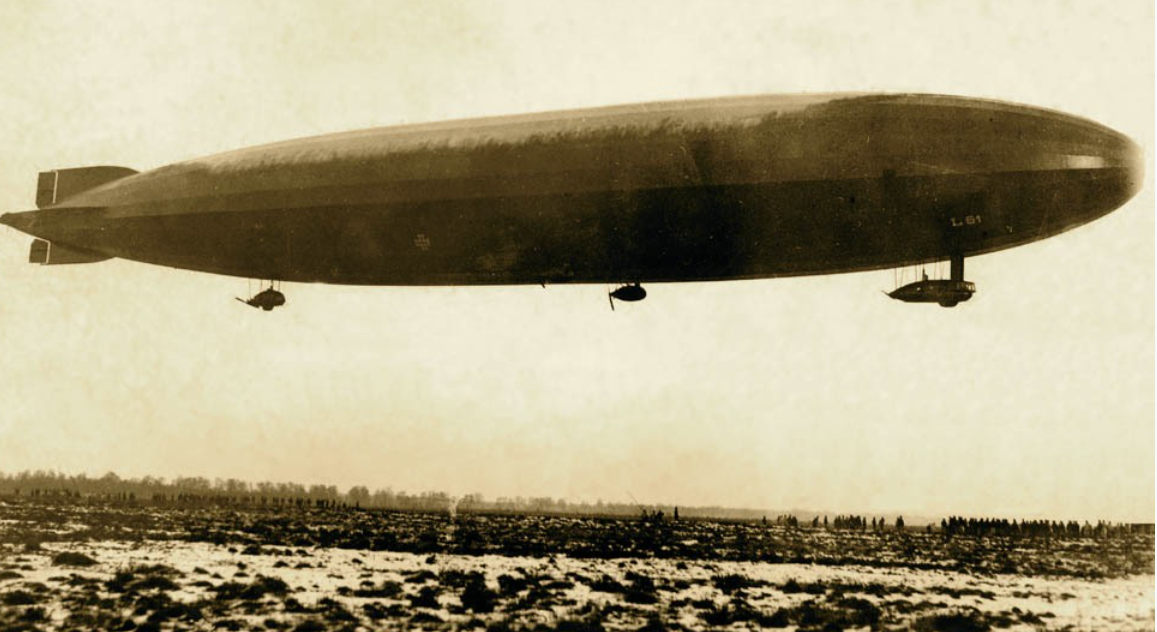 Zeppelin LZ106 L61 hovering over a field while ground crew is waiting